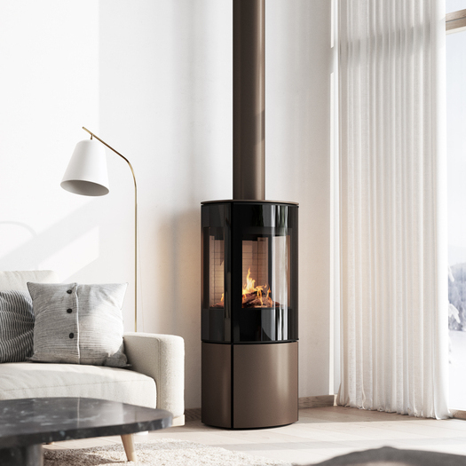 Stufa a gas CARO 110 in versione moca con porta del focolare a vetro pieno e finestra laterale nell'accogliente soggiorno