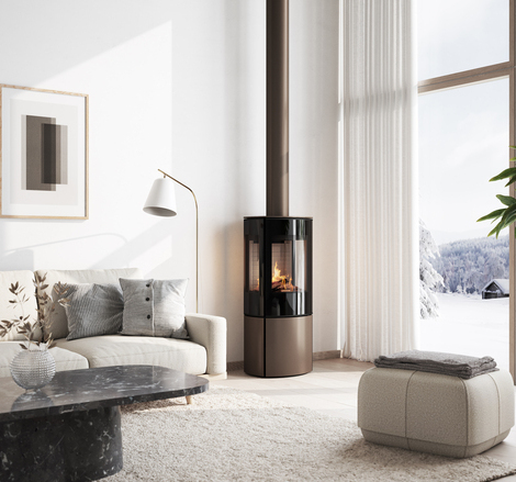 Stufa a gas CARO 110 in versione moca con porta del focolare a vetro pieno e finestra laterale nell'accogliente soggiorno