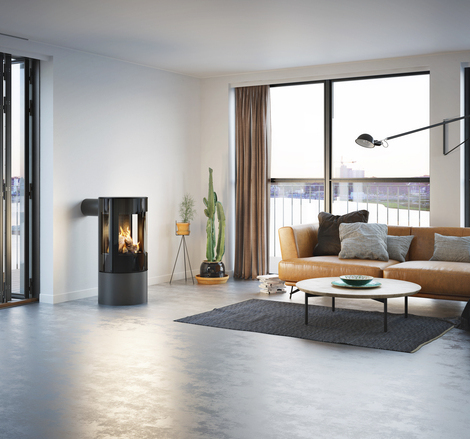 Stufa a gas VIVA 100 L in platino con porta del focolare in vetro in un appartamento minimalista con vista sullo skyline