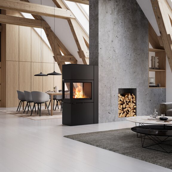 Stufa 600 RD di colore nero in un soggiorno luminoso e moderno con elementi in legno e parete in calcestruzzo