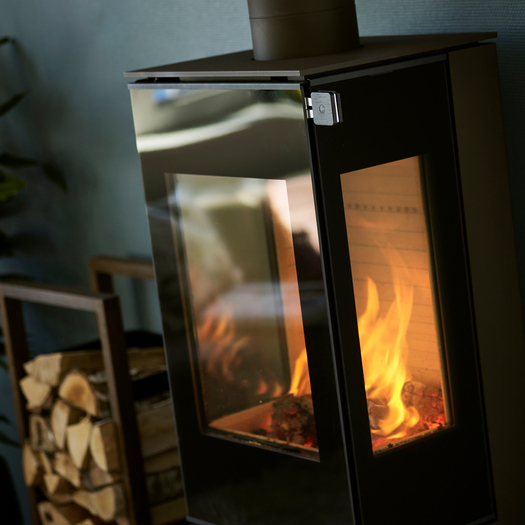 Stufa a legna NEXO 120 in nero con porta del focolare in vetro e due finestre laterali e maniglia in rovere nero
